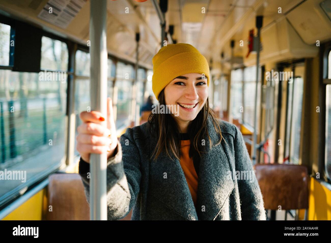 Giovane donna in piedi in un vagone di un tram di guida. Trasporto, corsa e concetto di stile di vita. Foto Stock