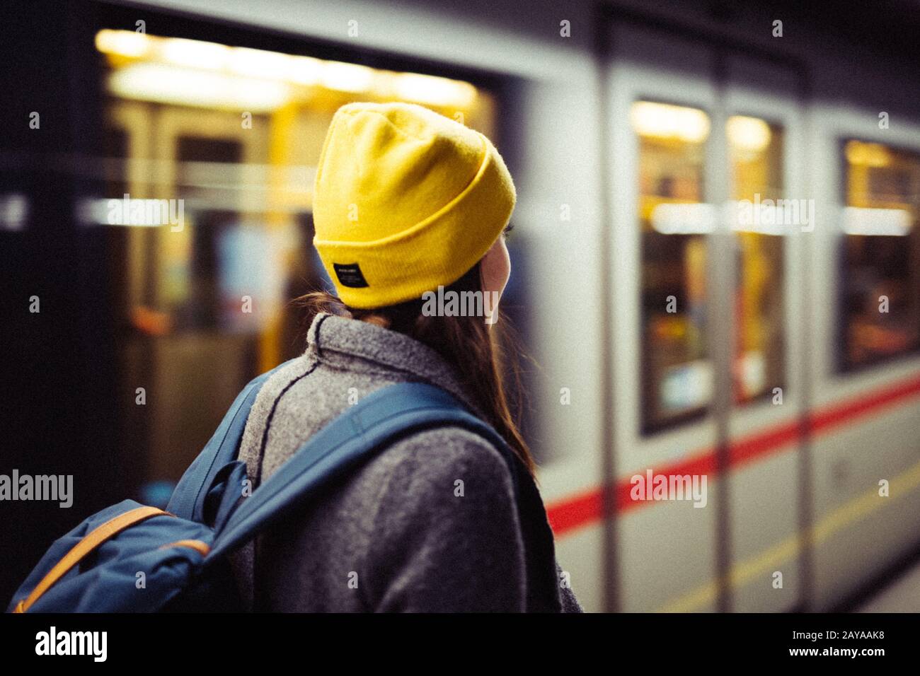 Giovane donna resta in attesa presso la stazione della metropolitana mentre il treno arrrives. Il trasporto e il concetto di viaggio. Foto Stock