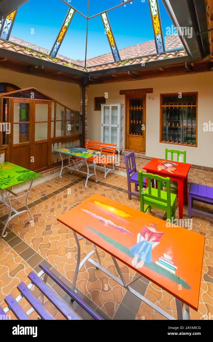 Patio coperto con tavoli decorati in casa coloniale Foto Stock