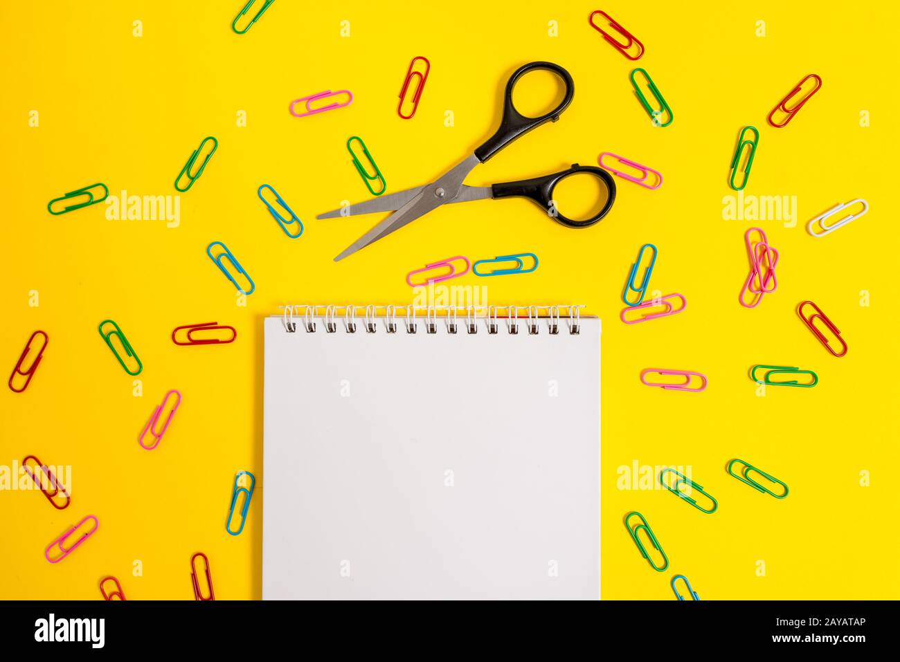Vuoto senza colore spirale notepad messaggi promemoria clip forbici sfondo colorato. Note vuote importanti eventi futuri stationa Foto Stock