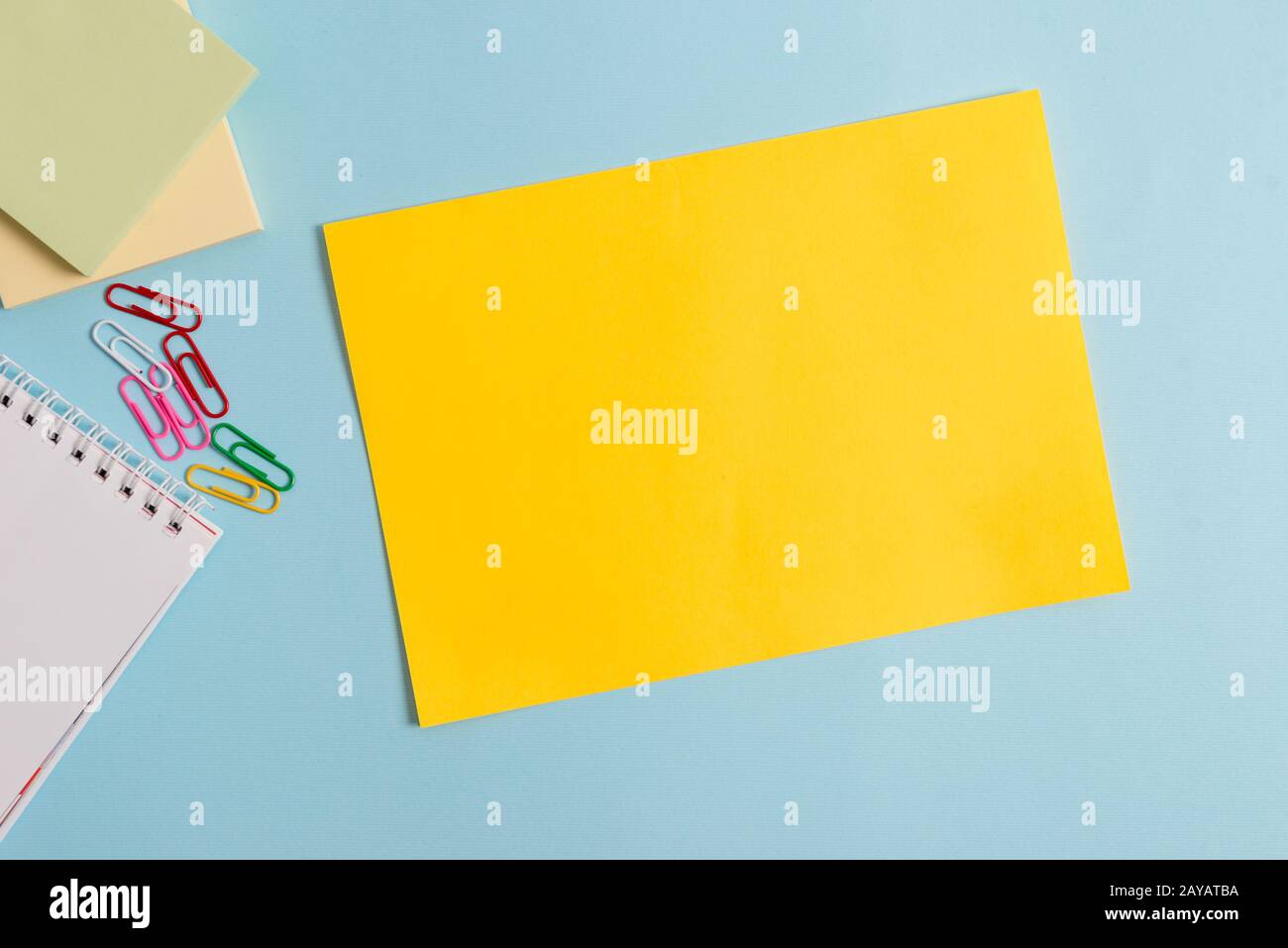 Semplice cartone e attrezzatura di scrittura posto sopra sfondo pastello. Carta più bastone fisso a sfondo moderno e senza motivi Foto Stock