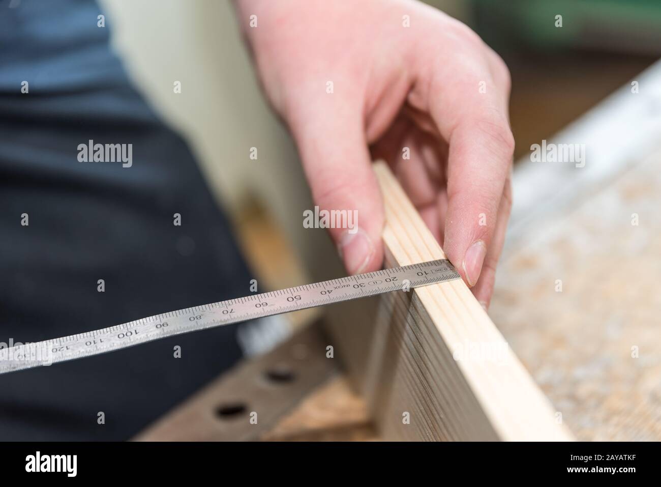 Carpentiere manca con nastro metro legno bordo - primo piano di lavoro Foto Stock