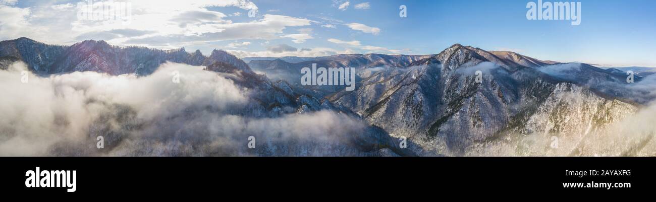 Una grande antenna panoramico vista orizzontale della snowy imponente montagna in presenza di luce solare. Il pittoresco e una stupenda scena. Foto Stock