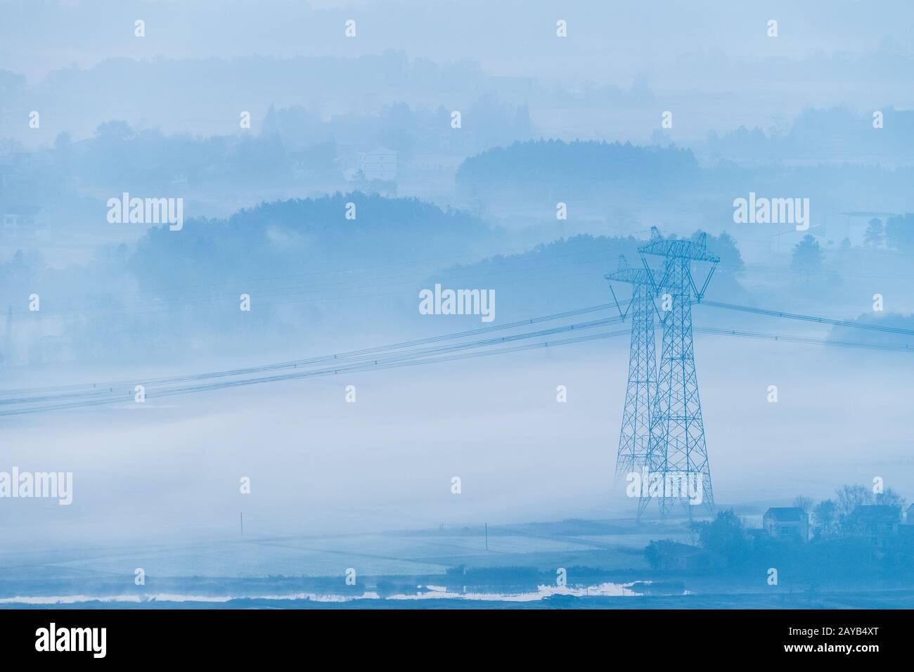 torri di trasmissione di potenza nella nebbia mattutina Foto Stock