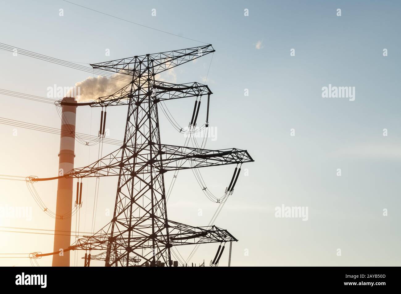 power trasmissione torre e camino al crepuscolo Foto Stock