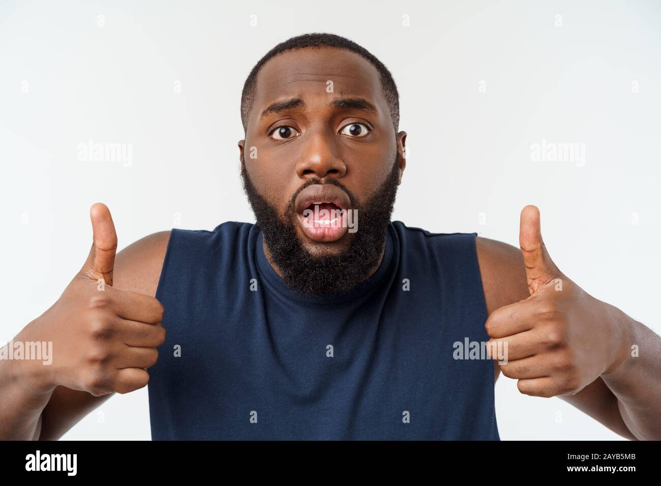 Giovane americano africano uomo su sfondo isolato indossando sport usura sorridente con la faccia felice guardando con il pollice verso l'alto. Foto Stock