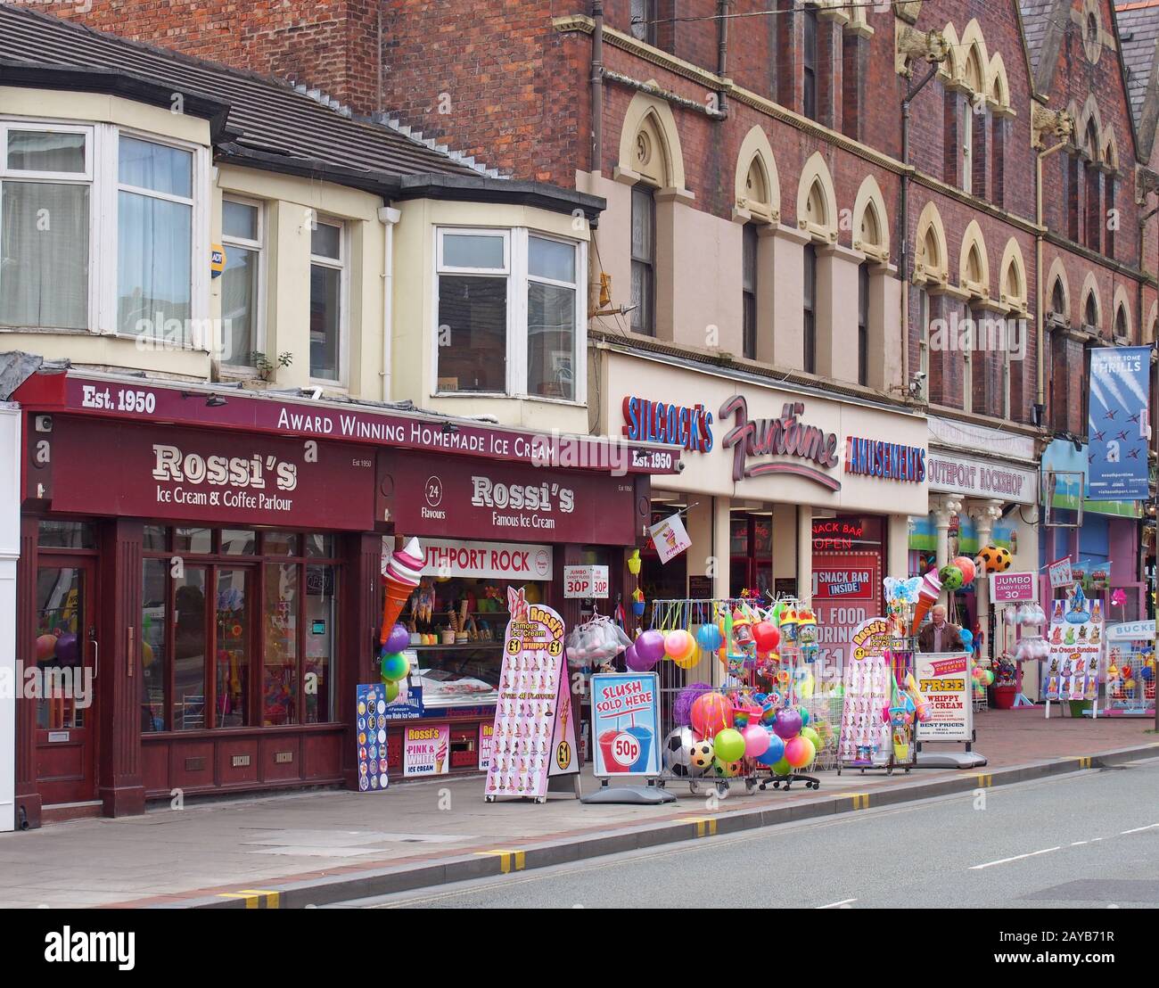 una fila di negozi neville street a southport merseyside vendere gelati rock beach giocattoli snack e candyfloss con e divertimento Foto Stock