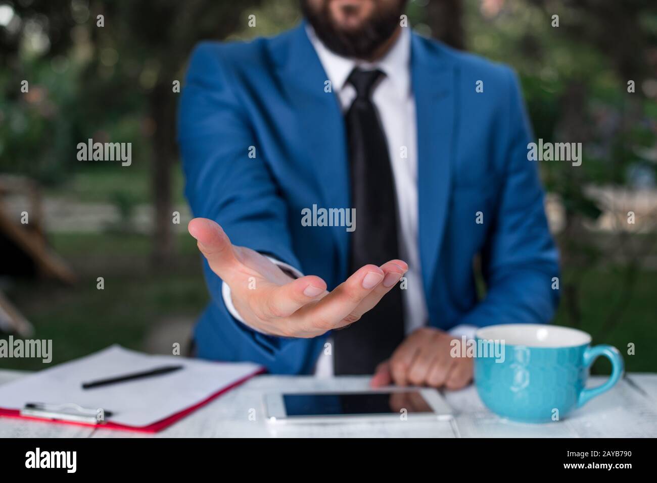 Uomo con le mani aperte davanti al tavolo. Telefono cellulare e note sul tavolo. Concetto di business con l'uomo nella suite. Foto Stock