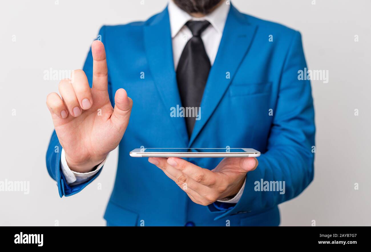 Uomo d'affari con dito puntato davanti a lui. L'uomo d'affari tiene in mano la parte superiore del giro e punta con il suo dito. Foto Stock