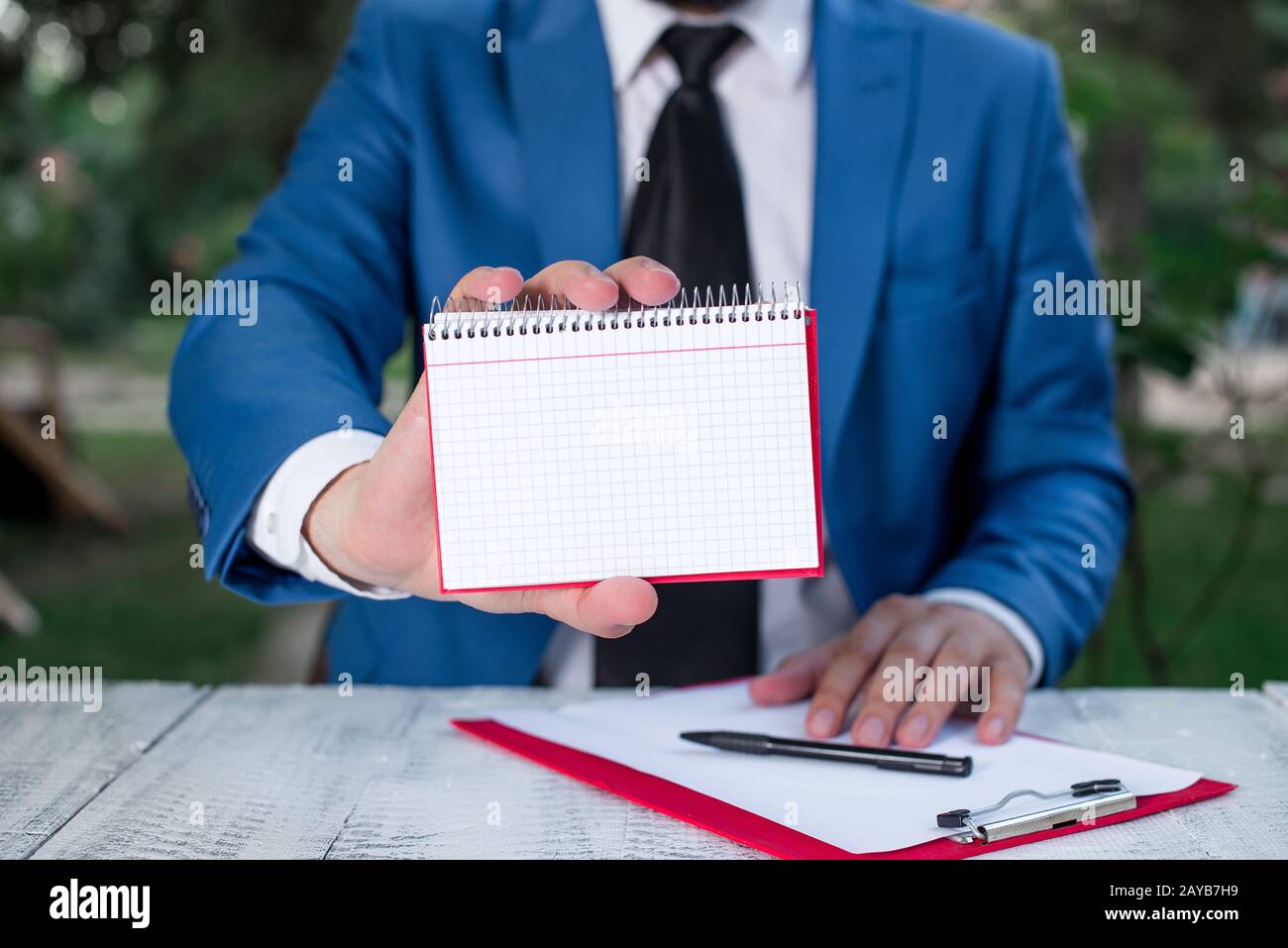 L'uomo tiene carta vuota con spazio per le copie davanti a lui. Concetto di business con l'uomo in una suite e una cravatta. Spazio bianco per pubblicità Foto Stock