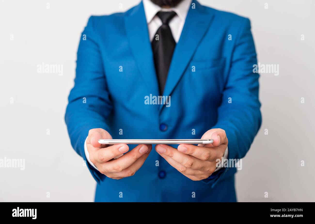 Uomo d'affari in suite blu con cravatta tiene il lap top in mano. Concetto di business con l'uomo in una suite e un lap top. Foto Stock