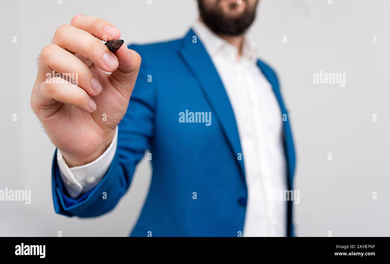 Uomo d'affari che punta con la penna nello spazio vuoto della copia. Concetto di business con l'uomo nella suite. Copia spazio con businessman in su Foto Stock