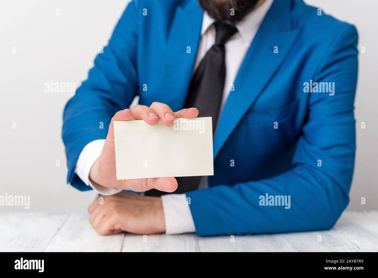 L'uomo tiene carta vuota con spazio per le copie davanti a lui. Concetto di business con l'uomo in una suite e una cravatta. Spazio bianco per pubblicità Foto Stock