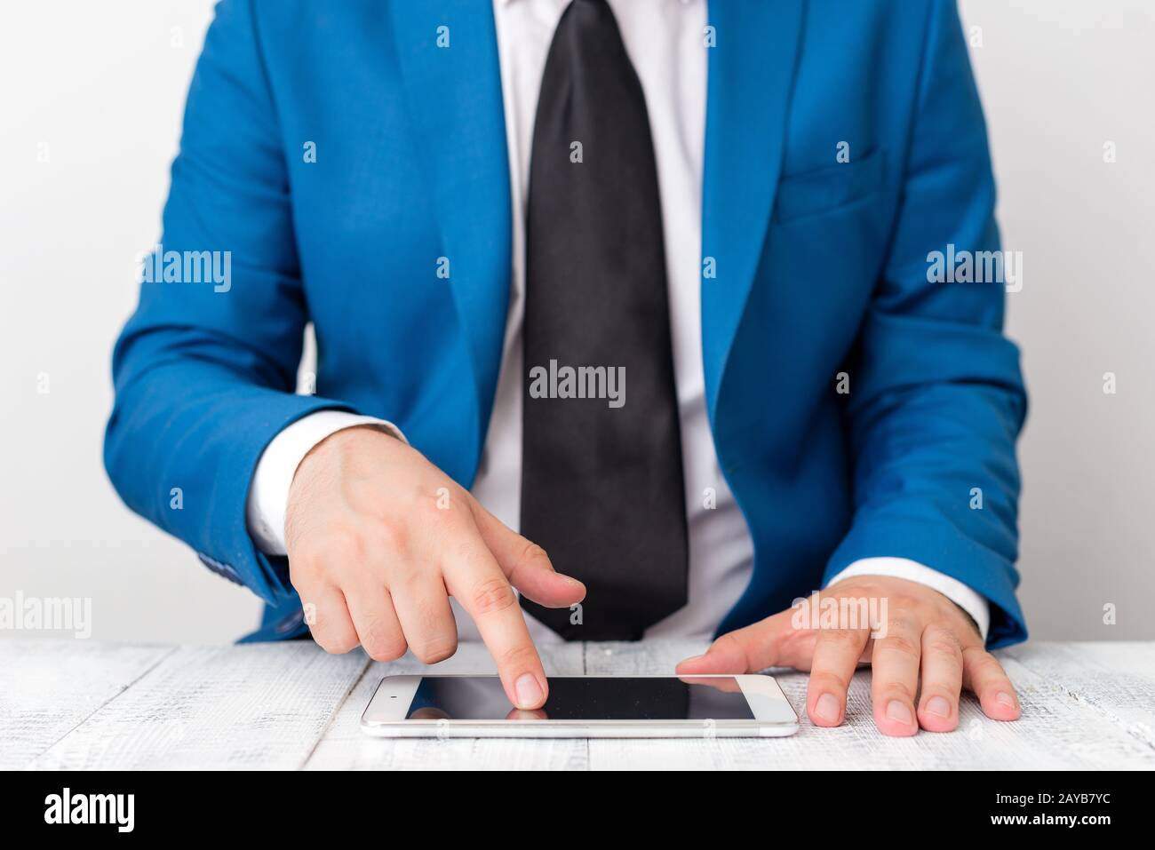 Uomo d'affari in suite blu con cravatta tiene il lap top in mano. Concetto di business con l'uomo in una suite e un lap top. Foto Stock