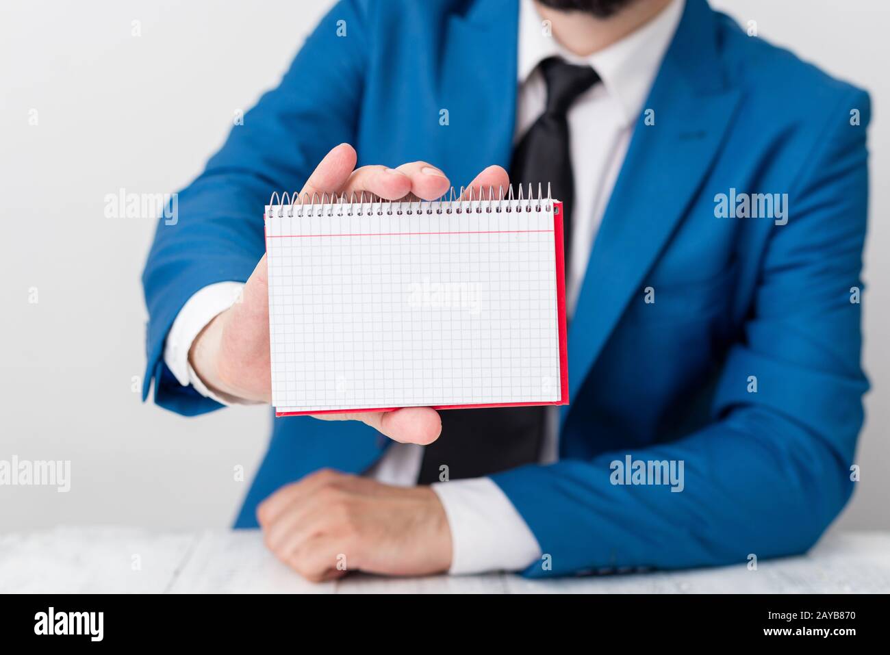 L'uomo tiene carta vuota con spazio per le copie davanti a lui. Concetto di business con l'uomo in una suite e una cravatta. Spazio bianco per pubblicità Foto Stock