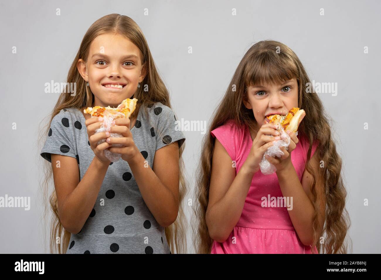 Due ragazze sono divertenti mangiare pane Foto Stock