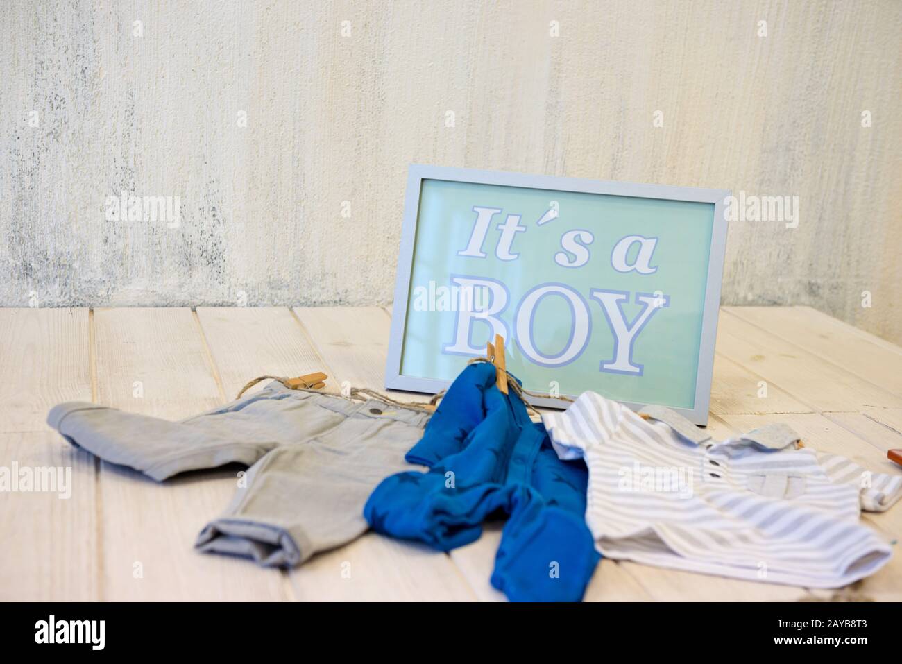 Cornice con testo e abiti per bambini in interni vuoti e luminosi Foto Stock