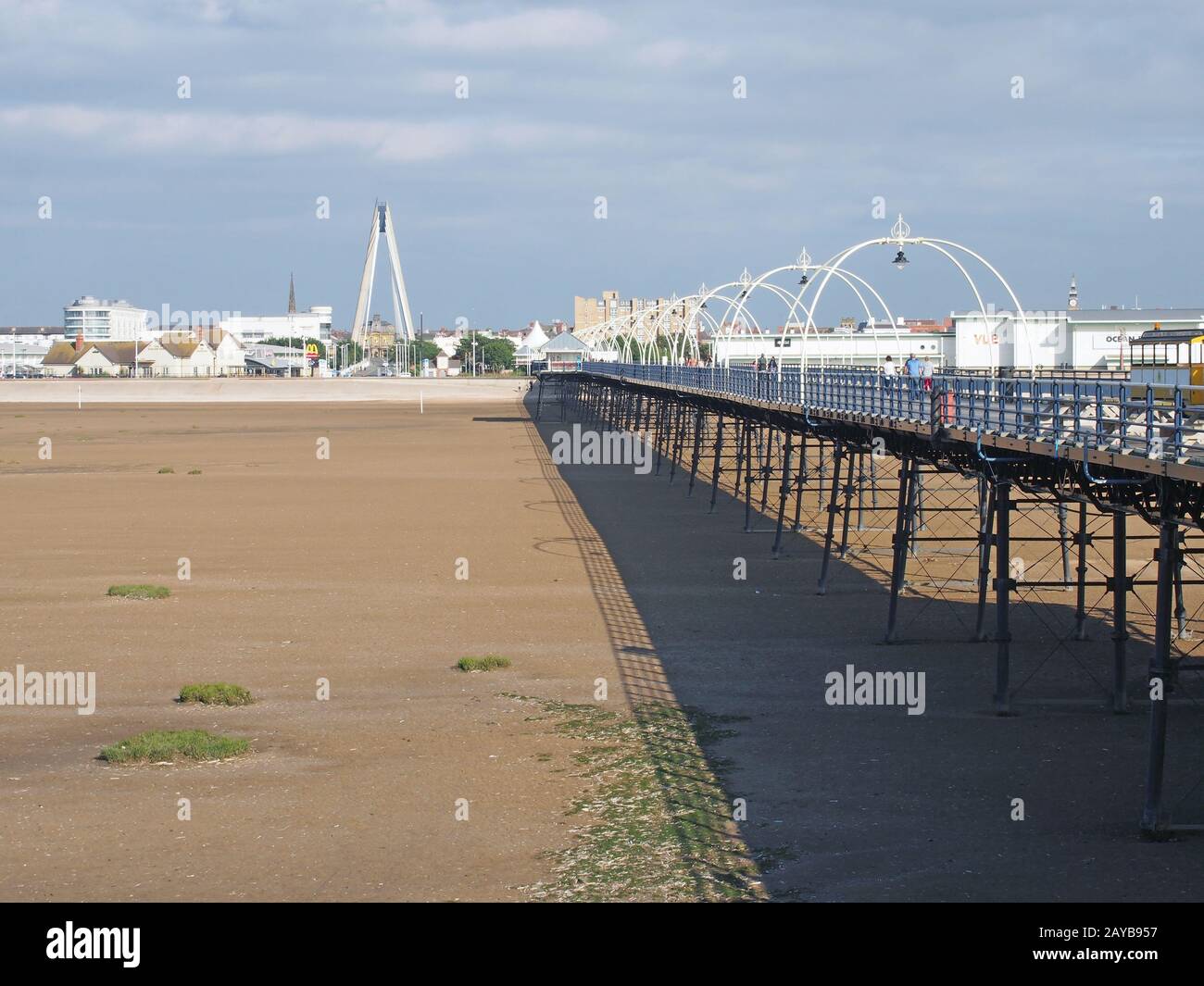 una vista panoramica del molo a southport merseyside con la spiaggia a bassa marea in una giornata estiva luminosa con la sospensione bridg Foto Stock