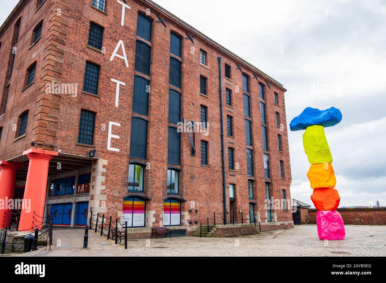 Esterno della galleria d'arte Tate Liverpool nell'area Albert Dock di Liverpool, Merseyside, con una scultura di Ugo Rondinone di nome Foto Stock