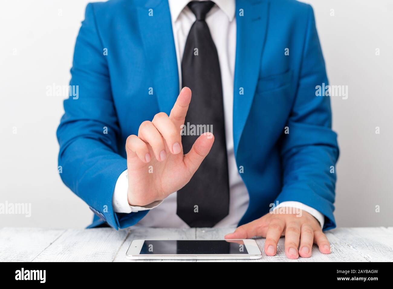 Uomo d'affari con dito puntato davanti a lui. L'uomo d'affari tiene in mano la parte superiore del giro e punta con il suo dito. Foto Stock