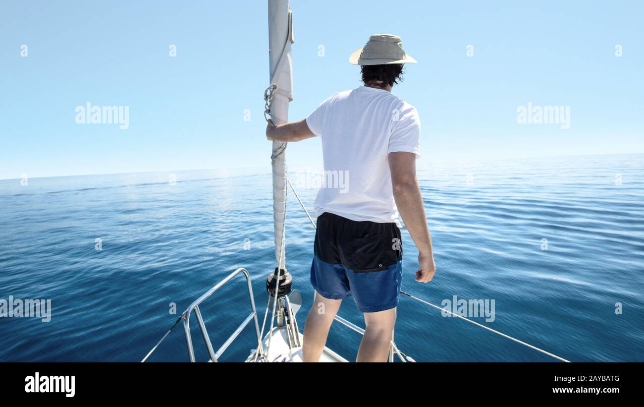 Uomo in piedi sulla prua di una nave. Yachting, vacanze e concetto di libertà. Foto Stock