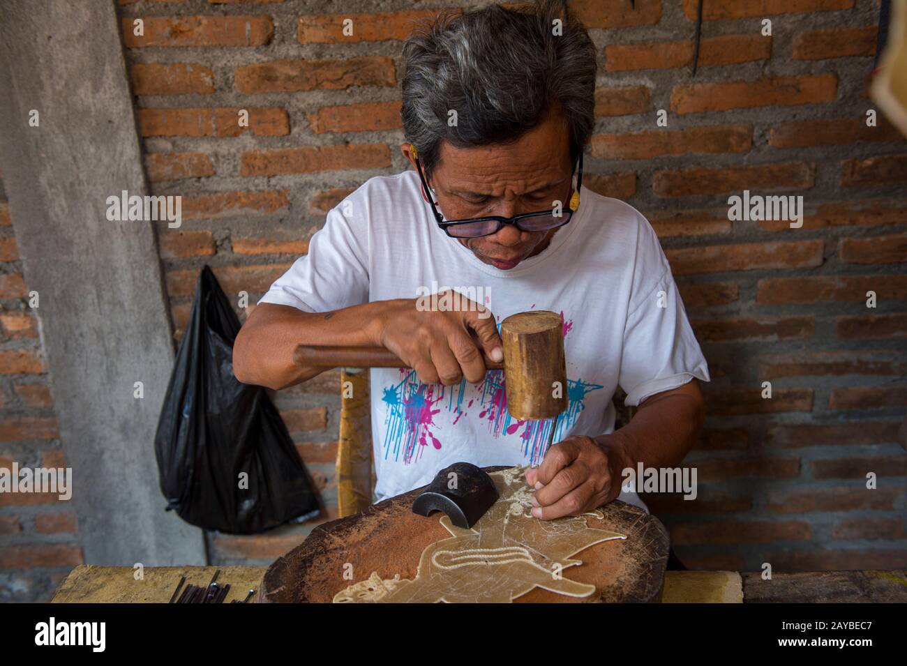 Un uomo sta facendo tradizionale caposaldo giavanese kulit (puppet ombra) di pelle a Yogyakarta, Java, Indonesia. Foto Stock