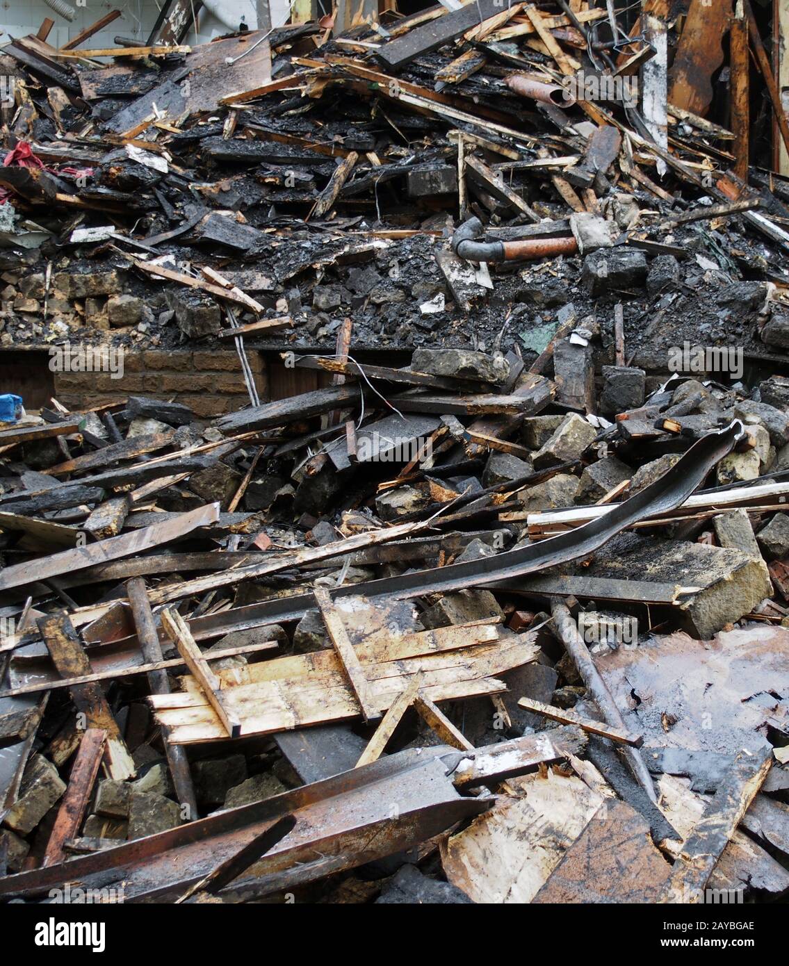 un mucchio di mattoni bruciati e sparsi travi e macerie dopo un incendio in un grande edificio Foto Stock