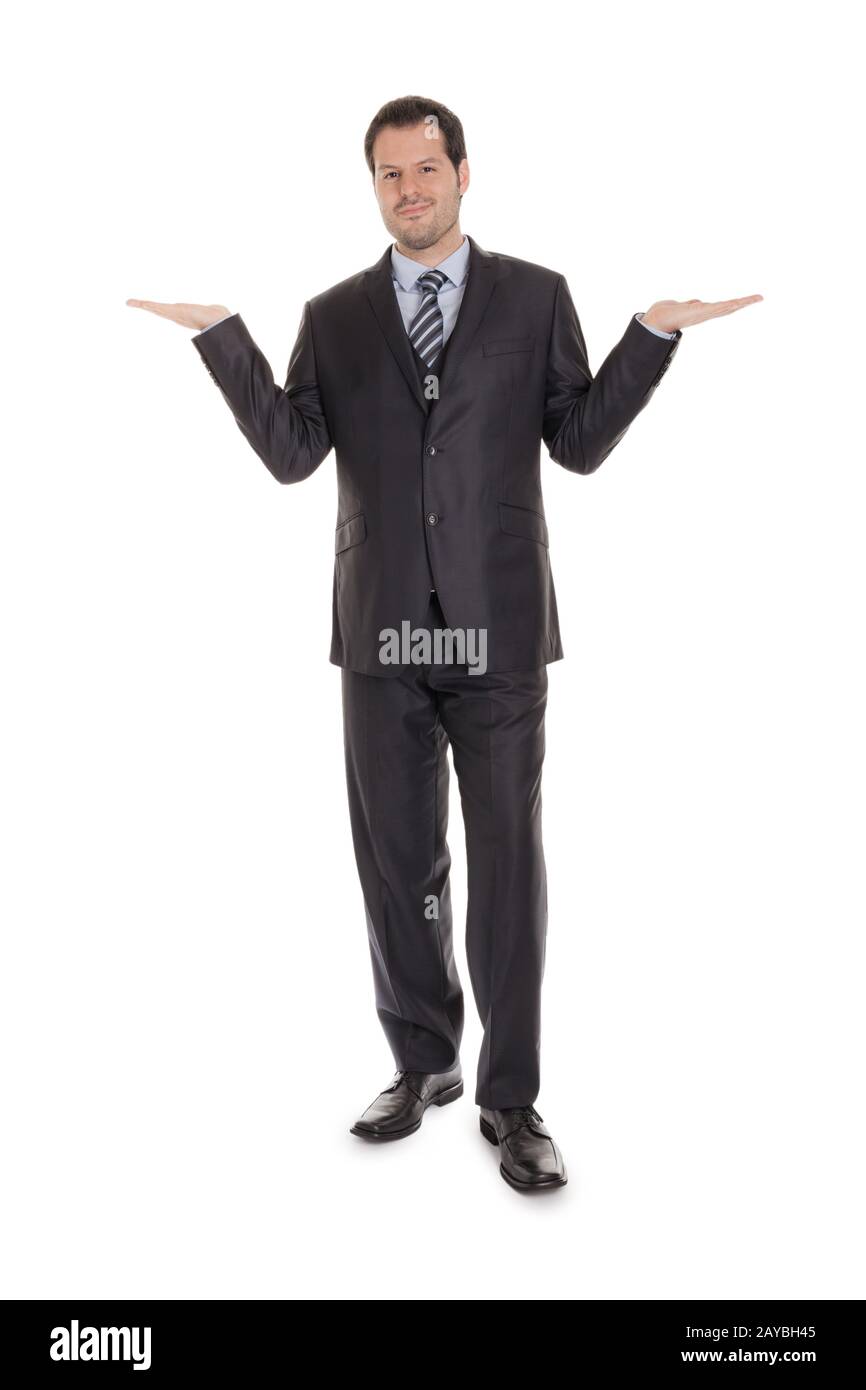Uomo d'affari intelligente in tuta nera con corpo intero isolato su sfondo bianco. Azienda c Foto Stock