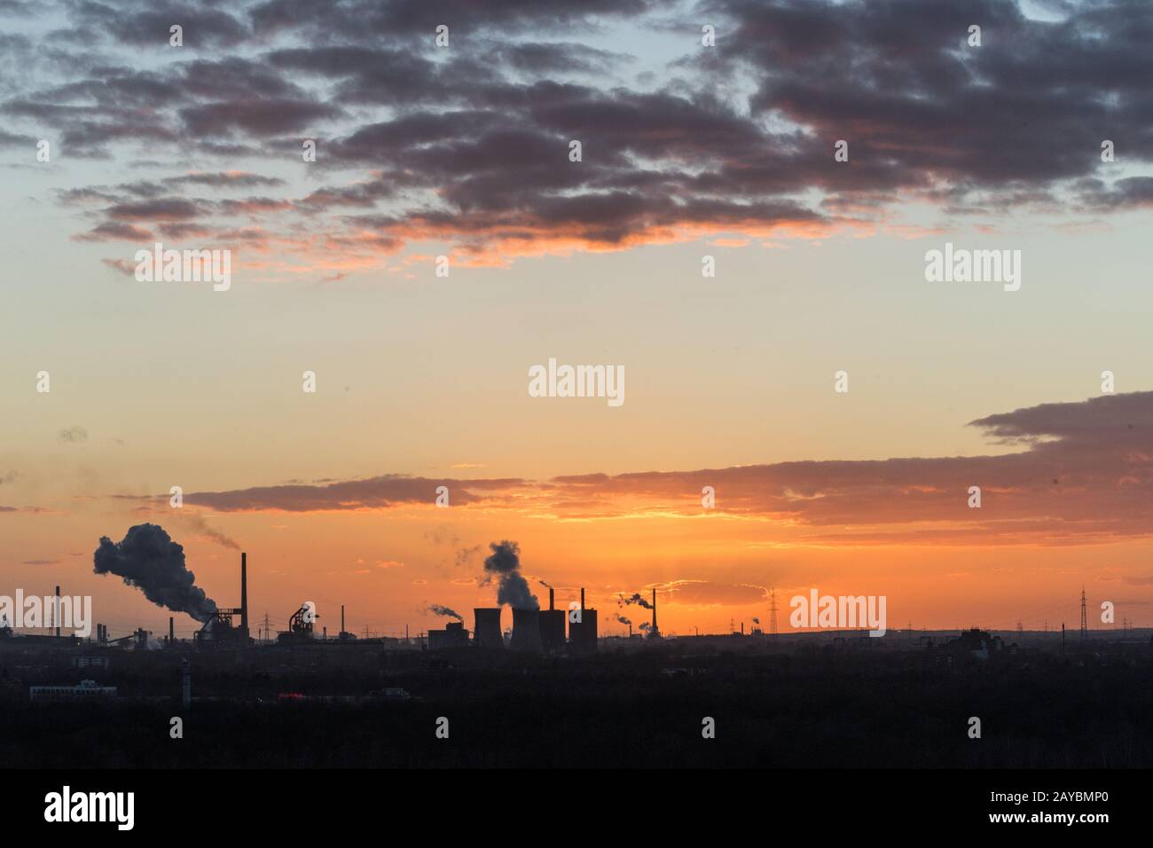 Sonnenuntergang an der Sechs-Seen-Platte in Duisburg mit Blick auf die rauchenden Schlote am Horizont Foto Stock