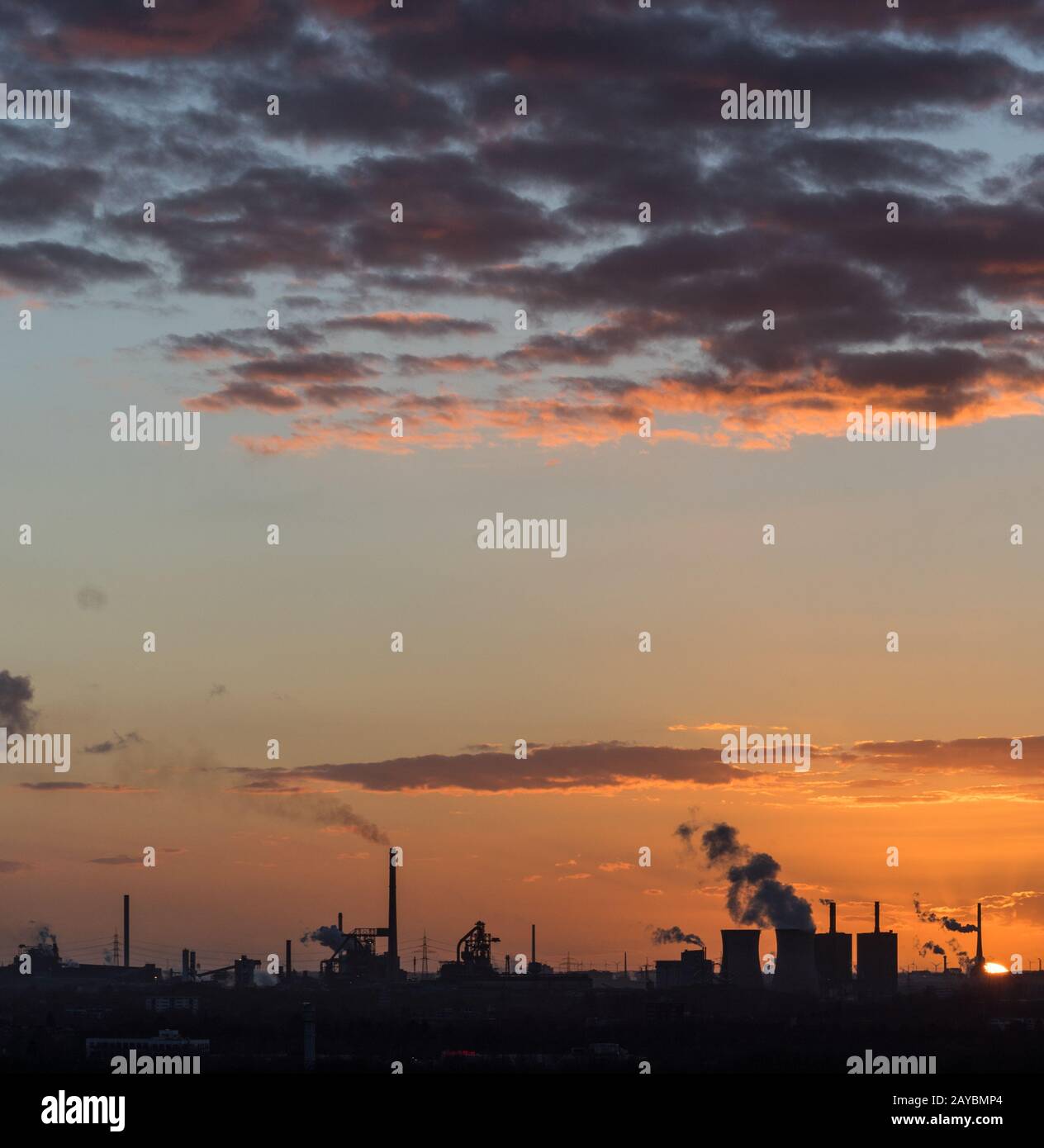 Sonnenuntergang an der Sechs-Seen-Platte in Duisburg mit Blick auf die rauchenden Schlote am Horizont Foto Stock