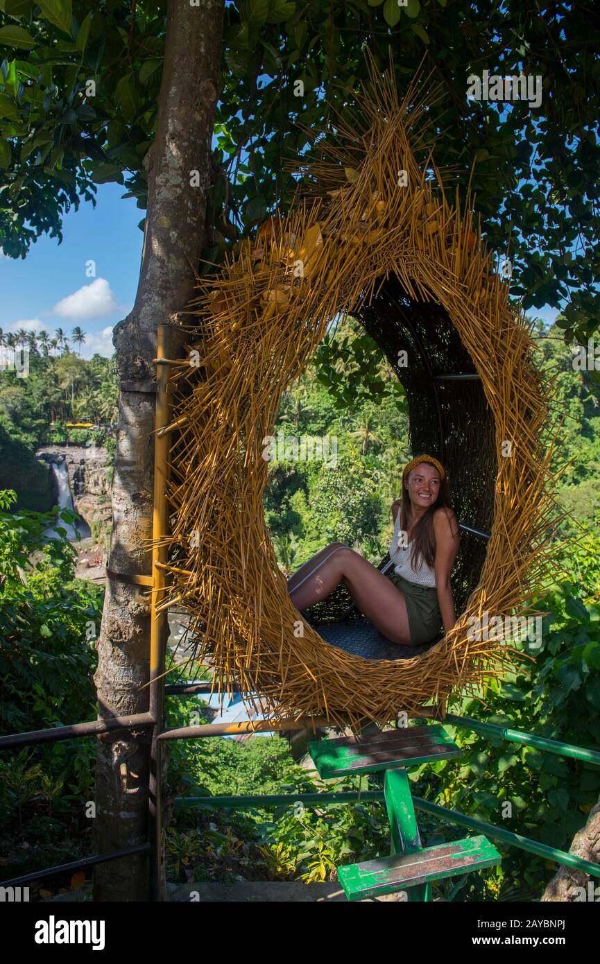 Un turista sta posando per le foto davanti alla cascata Tegenungan (Fiume Tukad Petanu) vicino a Ubud, Bali Indonesia. Foto Stock
