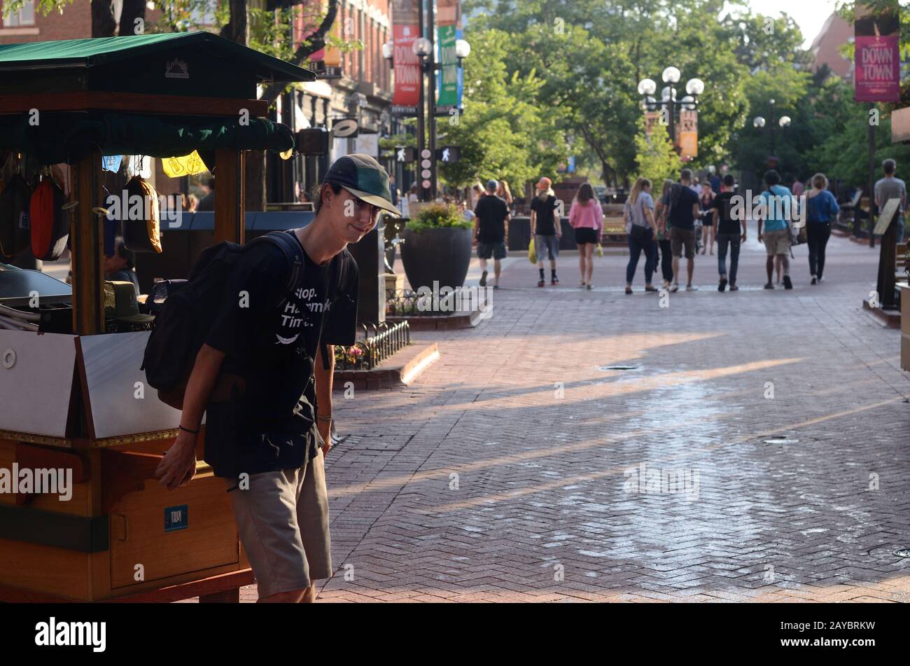 Un venditore di strada sul Pearl Street Mall chiude il negozio e sposta il carrello alla fine della giornata. Estate, Foto Stock