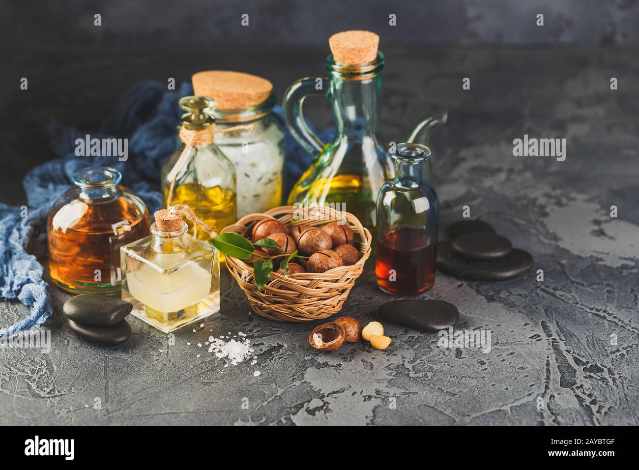 Olio di macadamia naturale in bottiglia di vetro con noci di macadamia Foto Stock