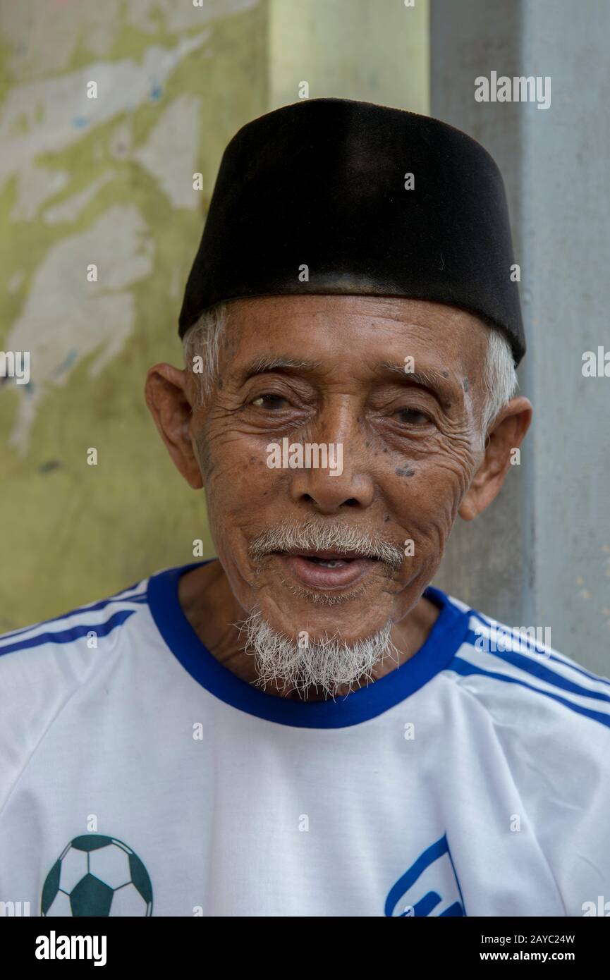 Una scena di villaggio con un ritratto di un anziano nel villaggio gitana del mare di Bajau sull'isola di Bungin, famoso per vivere in case di palafitta sopra l'acqua A. Foto Stock