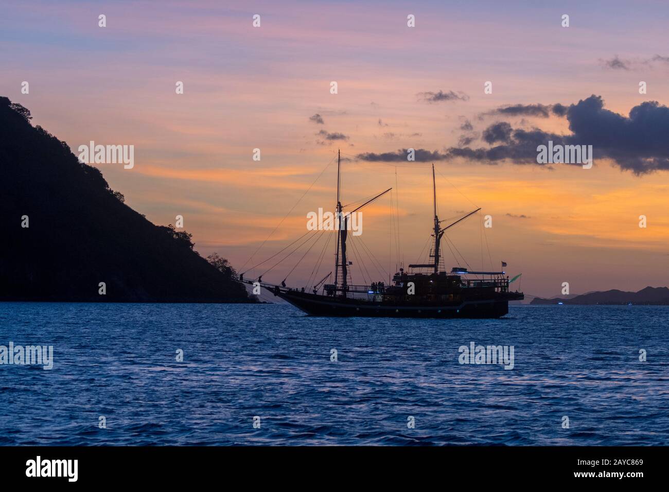 Un'escursione turistica in barca passa dall'isola di Kelor al tramonto, un'isola isolata a circa 10 chilometri da Labuan Bajo, Flores e vicino a Kom Foto Stock