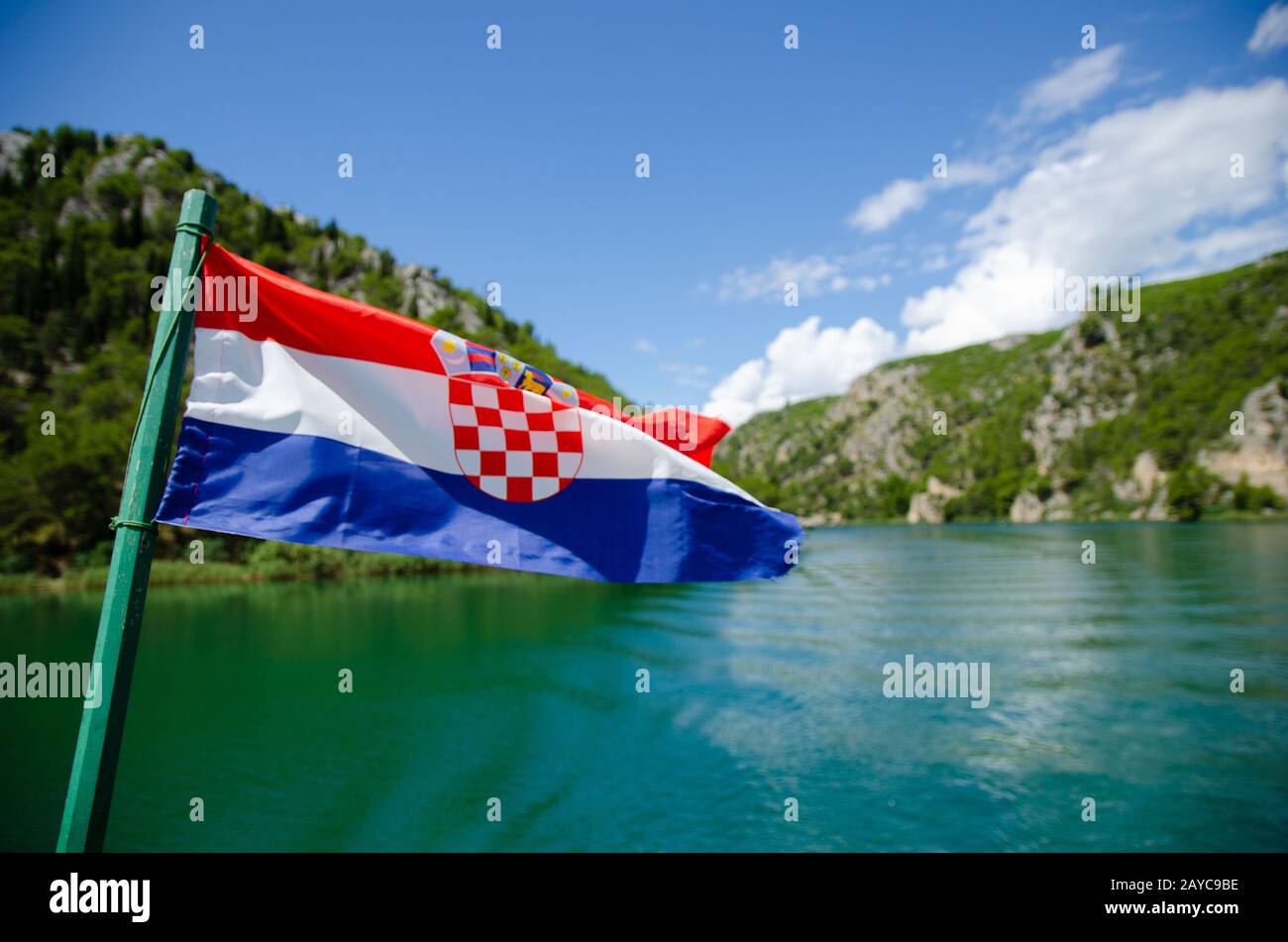 Barca su un fiume per le Cascate di Krka parco nazionale. Bandiera croata Foto Stock