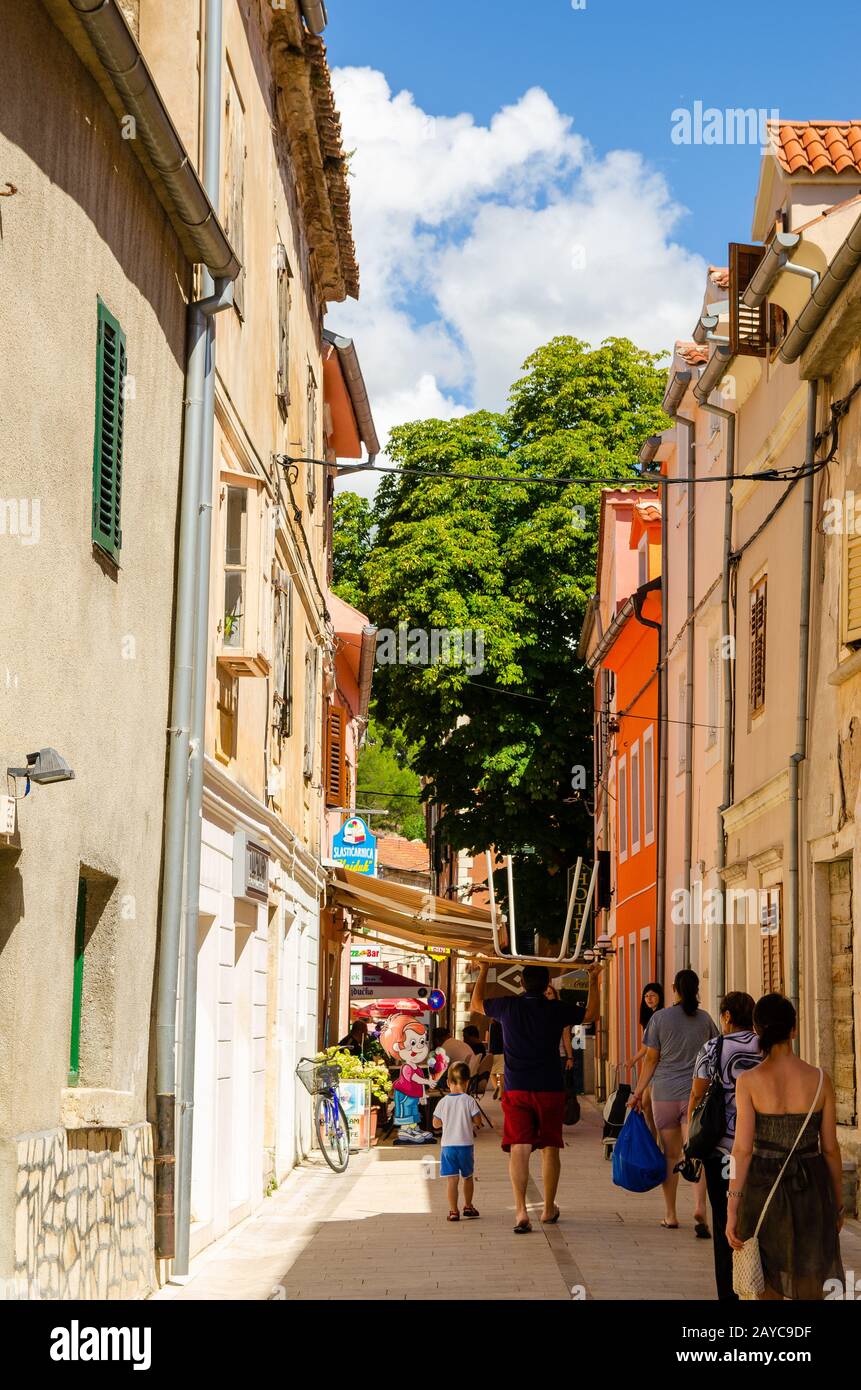 Una stretta strada a piedi della vecchia città turistica, la gente camminare da. Destinazione di viaggio in croato Costa Mediterranea. Foto Stock