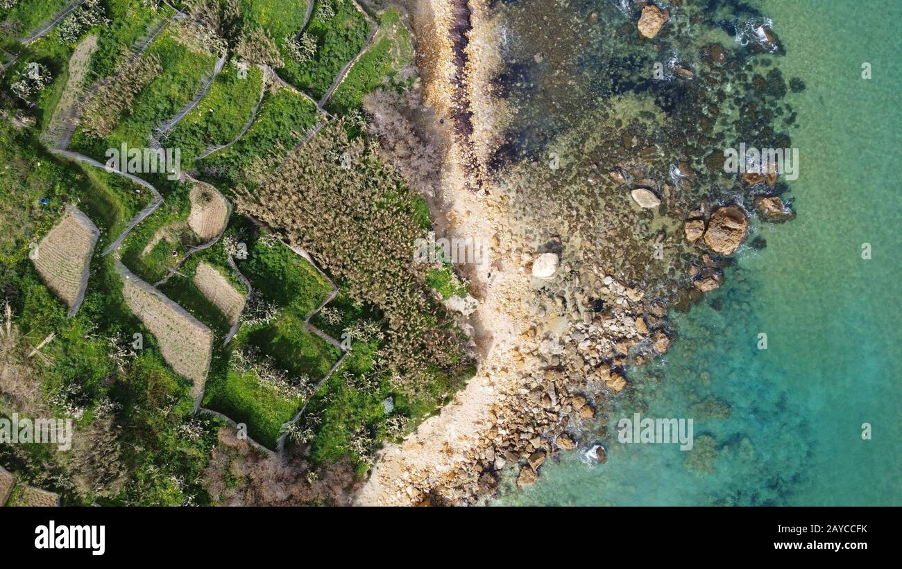 Veduta aerea della costa rocciosa del mare e della spiaggia di San Blas Bay a Gozo, l'isola più piccola di Malta Foto Stock