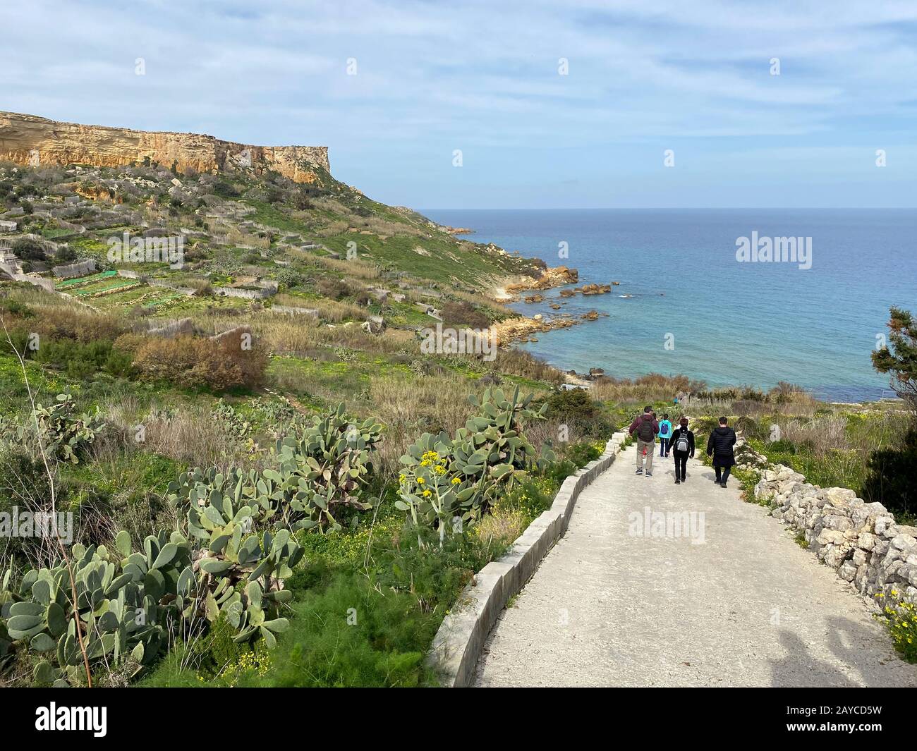 I turisti camminano lungo il sentiero verso la baia di San Blas a Gozo, l'isola più piccola di Malta Foto Stock