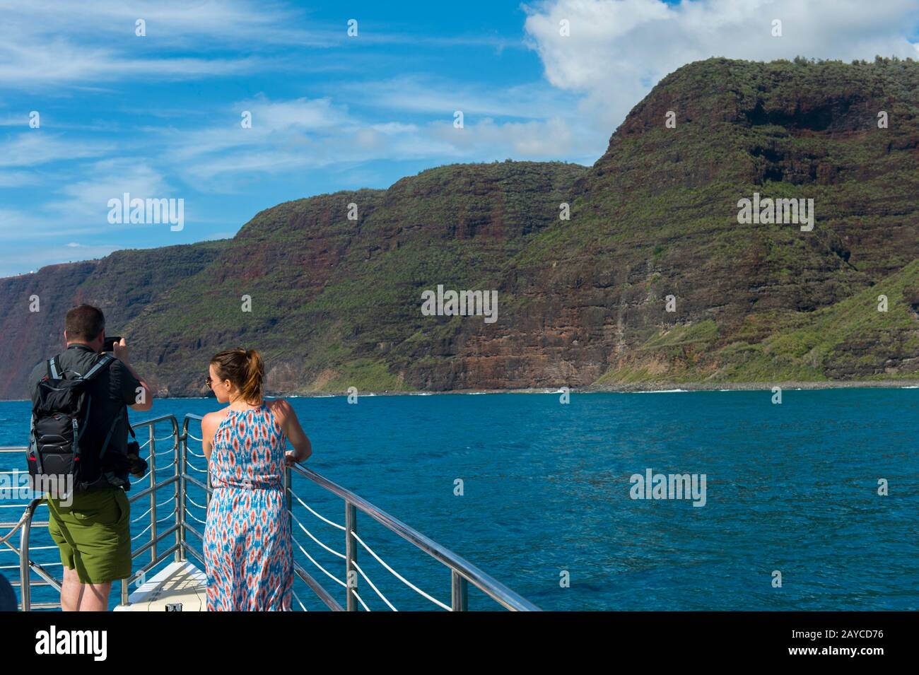 Persone in barca per escursioni che guardano la costa di Na Pali sul lato occidentale dell'isola hawaiana di Kauai, Hawaii, USA. Foto Stock