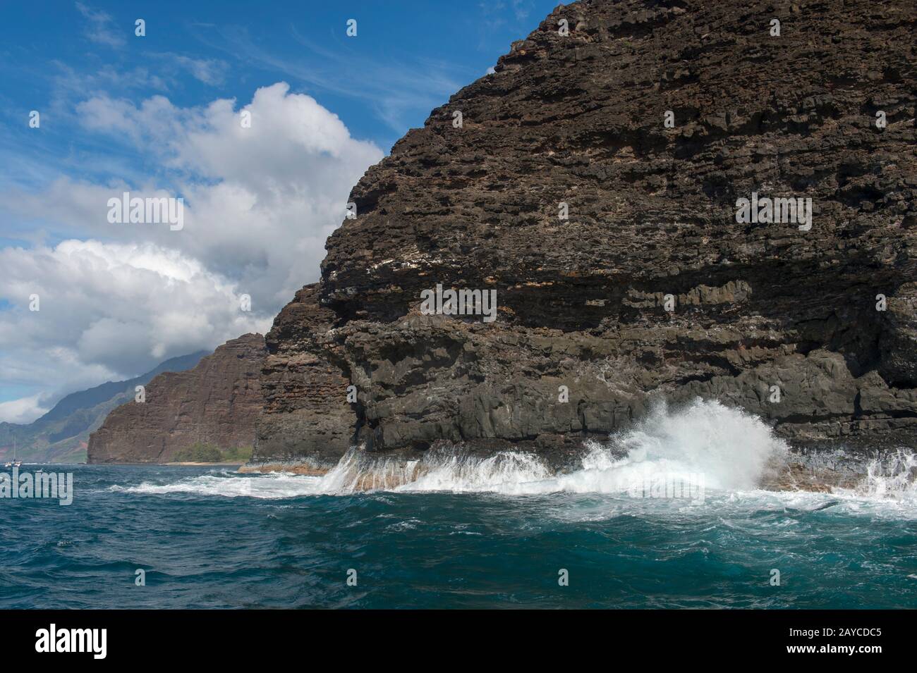 Il surf sta rompendo sulla costa di Na Pali sul lato occidentale dell'Isola Hawaiiana di Kauai, Hawaii, Stati Uniti. Foto Stock