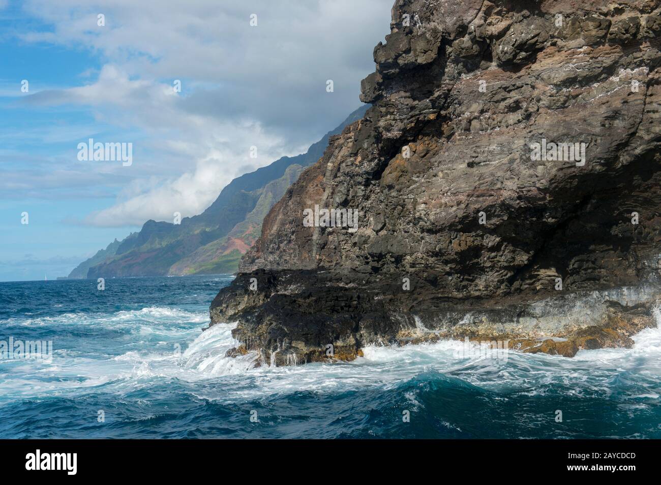 Il surf sta rompendo sulla costa di Na Pali sul lato occidentale dell'Isola Hawaiiana di Kauai, Hawaii, Stati Uniti. Foto Stock