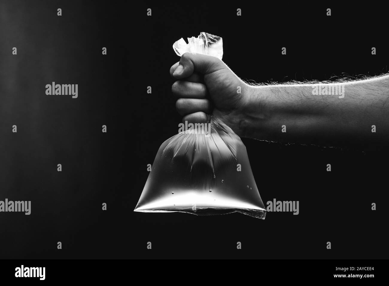 Mano maschio è in possesso di un vuoto sacchetto di plastica riempito con acqua pulita. Ambiente ed ecologia concetto. Foto Stock