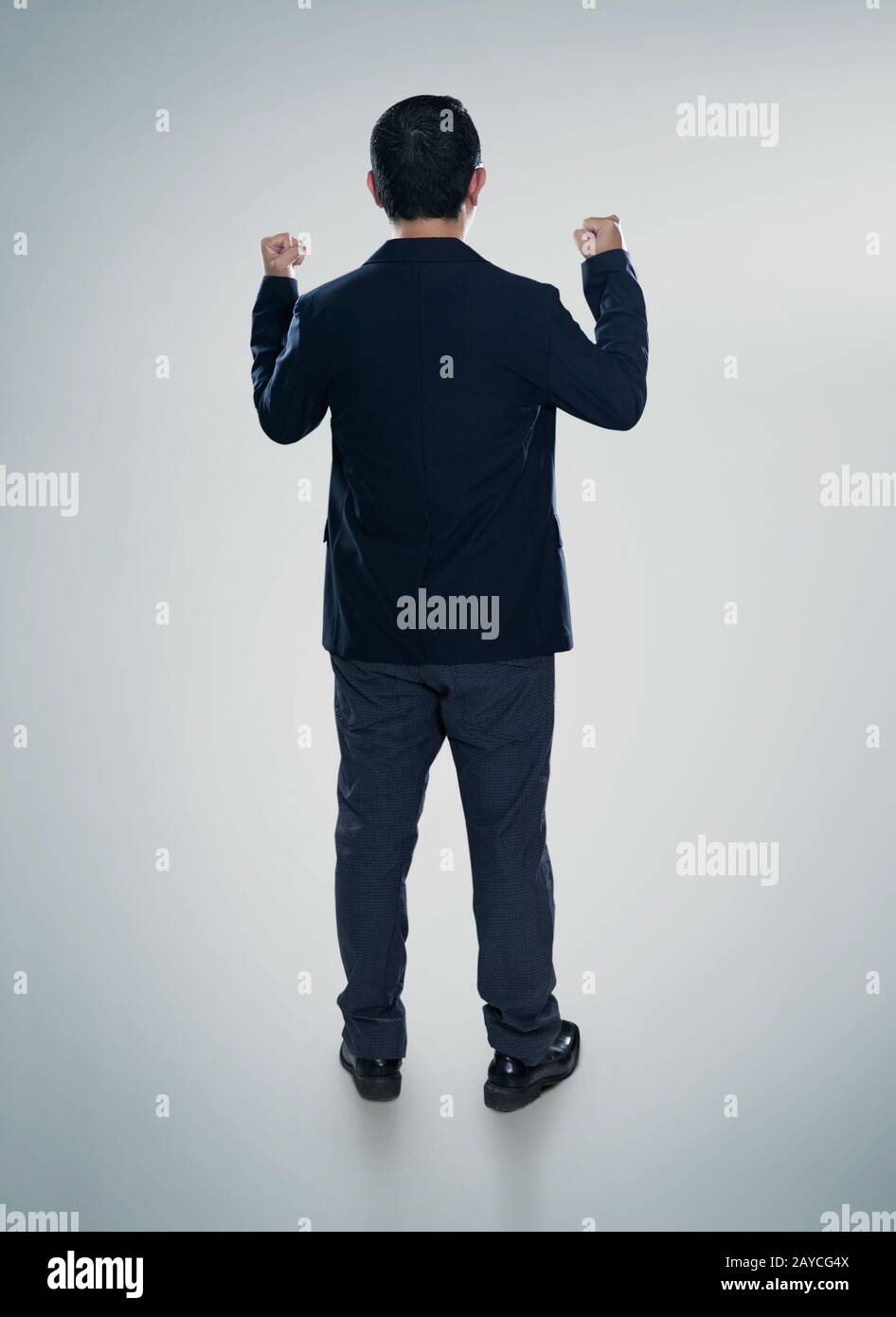 Vista posteriore di un uomo d'affari eccitato con le braccia in su Foto Stock