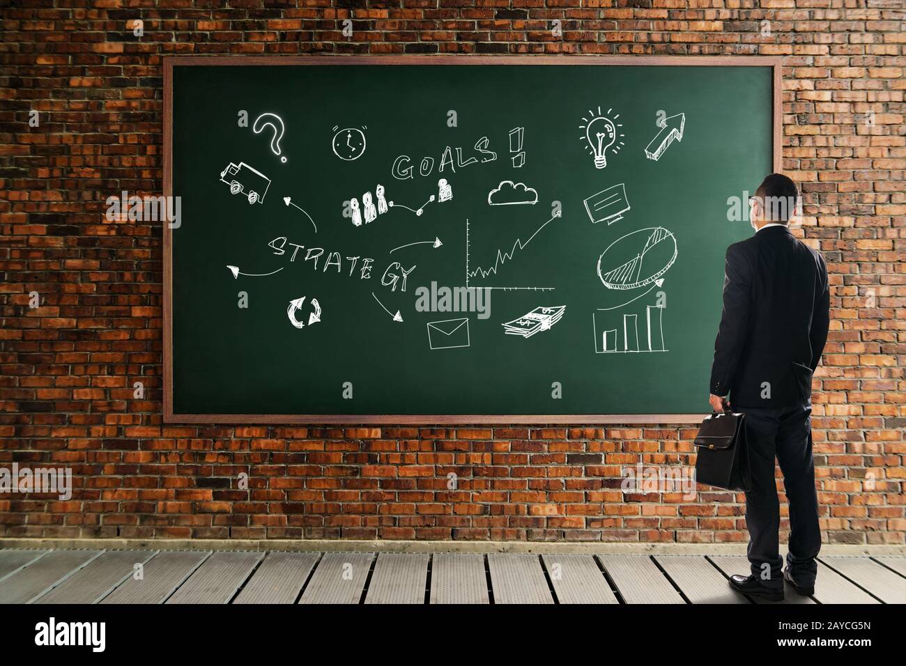 Uomo d'affari che guarda e thinkin davanti ad un muro di mattoni di lavagna con la strategia del grafico di sviluppo . Metafora di affari di così Foto Stock