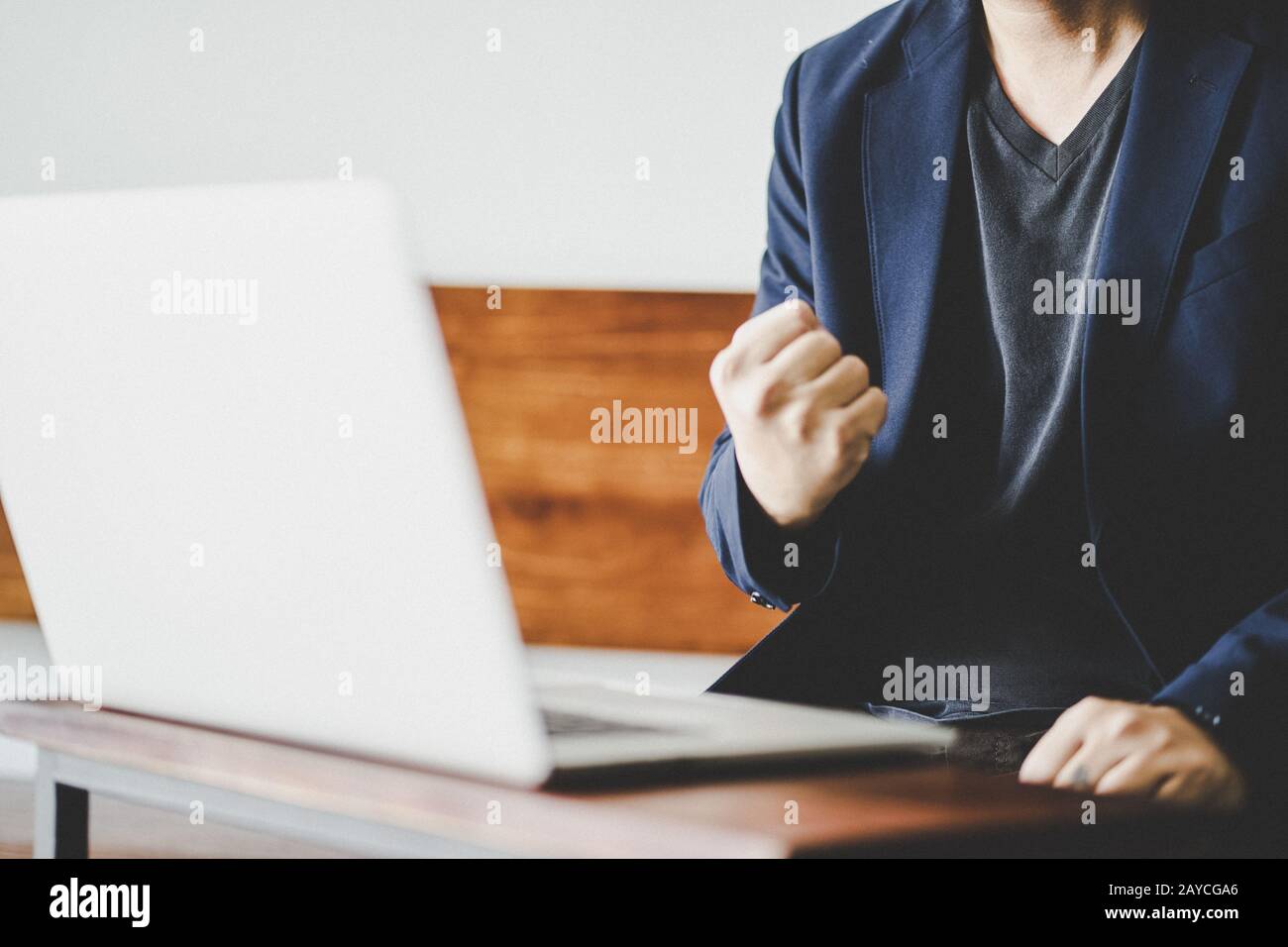 Un uomo d'affari di successo eccitato pugno clenched davanti al calcolatore Foto Stock