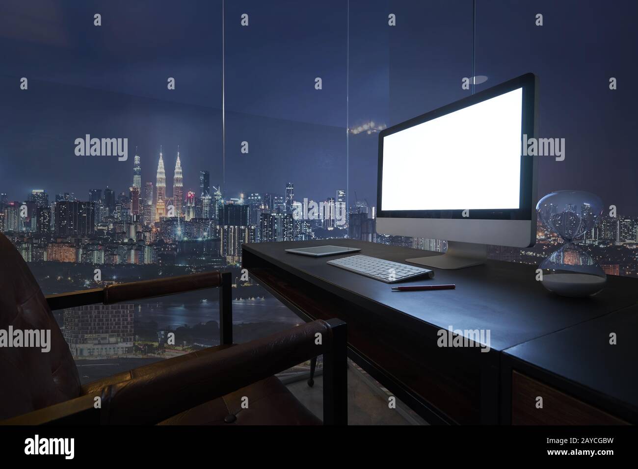 Computer sul desktop con vista dello skyline di Kuala Lumpur nel crepuscolo. Foto Stock