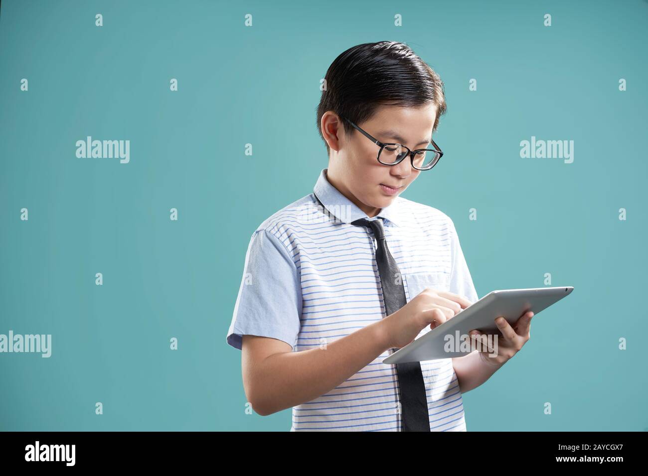 Ragazzo asiatico intelligente che usa il tablet digitale per imparare Foto Stock