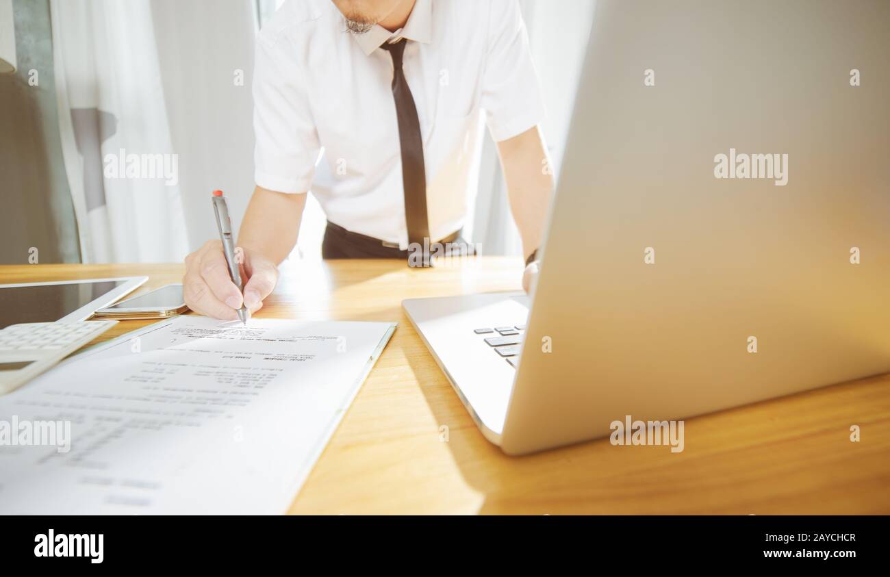 Uomo d affari con computer portatile e fare in modo che la decisione di firmare un grande progetto . Foto Stock