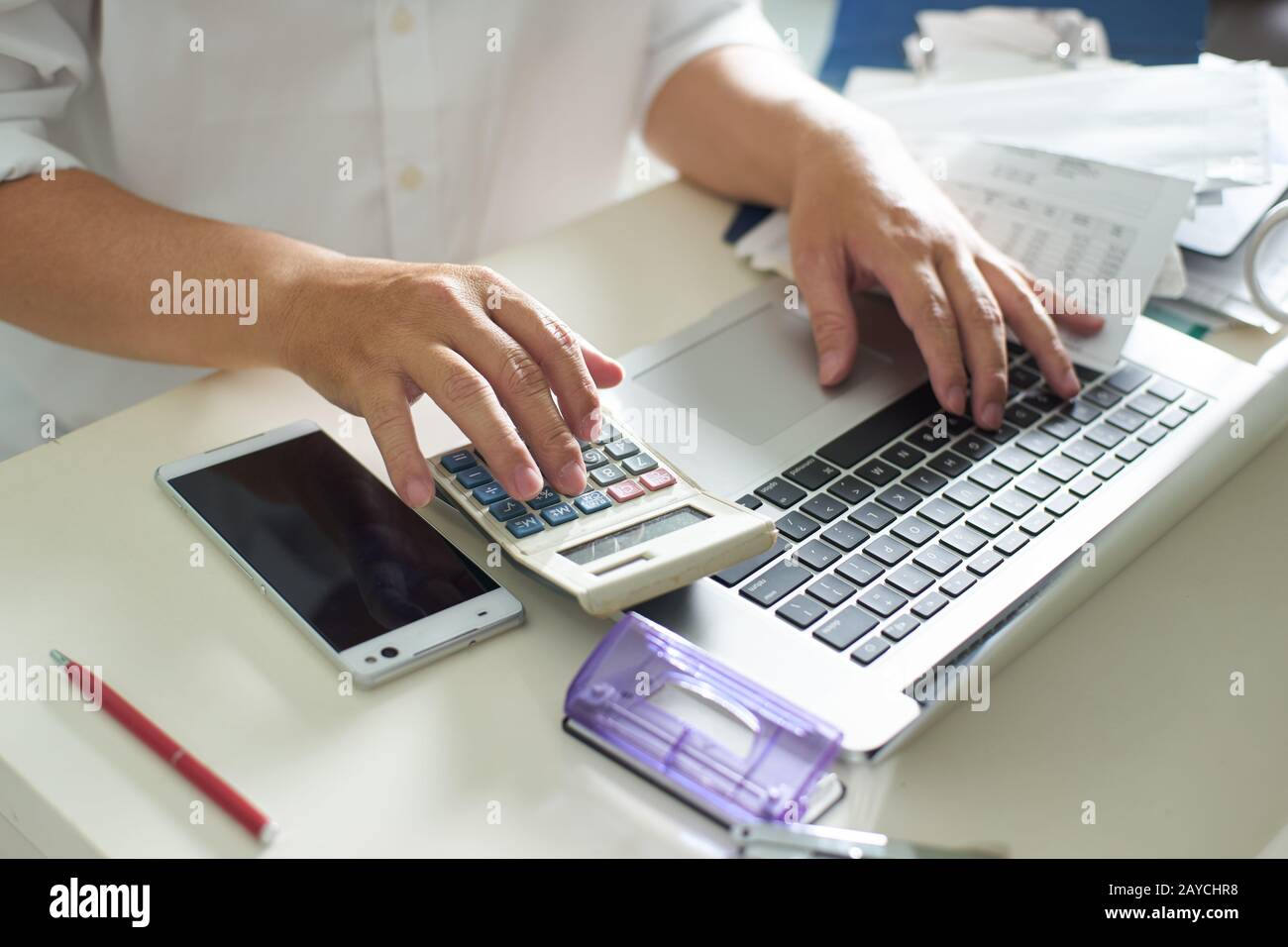 Gli uomini d' affari lavorare con la calcolatrice e il computer portatile sul tavolo bianco in ufficio Foto Stock
